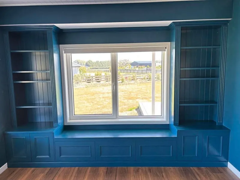 Built in painted shelving and window seat with panelled doors in a Canterbury home