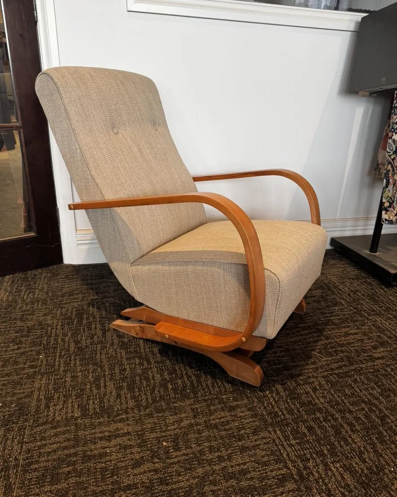 The same bentwood lounge chair after restoration, reupholstered in oatmeal wool tweed with polished arms