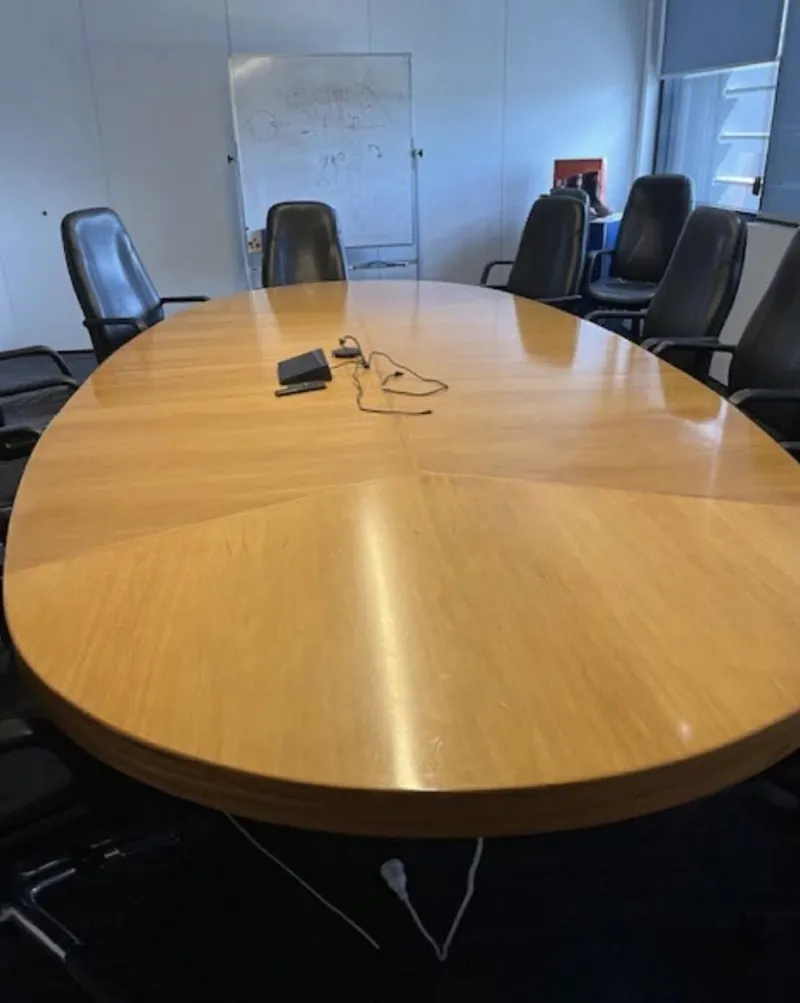 Skellerup boardroom table before restoration, faded and marked timber top